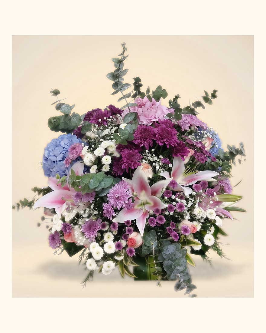 An arrangement of hydrangeas, lilies and roses in purple and pink