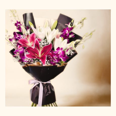 Pink lilies and purple orchids in a black wrap