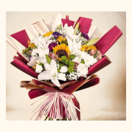 Sunflowers and white lilies in a maroon wrap