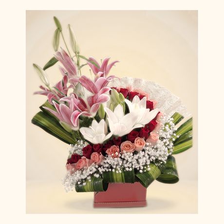 Pink and white lilies fanned above red roses