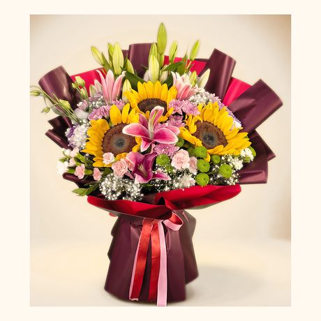 Sunflowers and pink lilies in a maroon and pink wrap