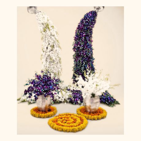 Two pillars of white and purple flowers rising from silver pots